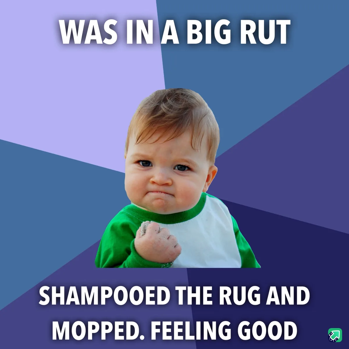 A baby with a scrunched-up, determined face wearing a green and white shirt, clenched fist covered in sand, set against a…