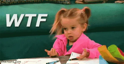 A young girl with blonde pigtails and a pink jacket sits at a table, her expression shifting from confusion to shock as she…