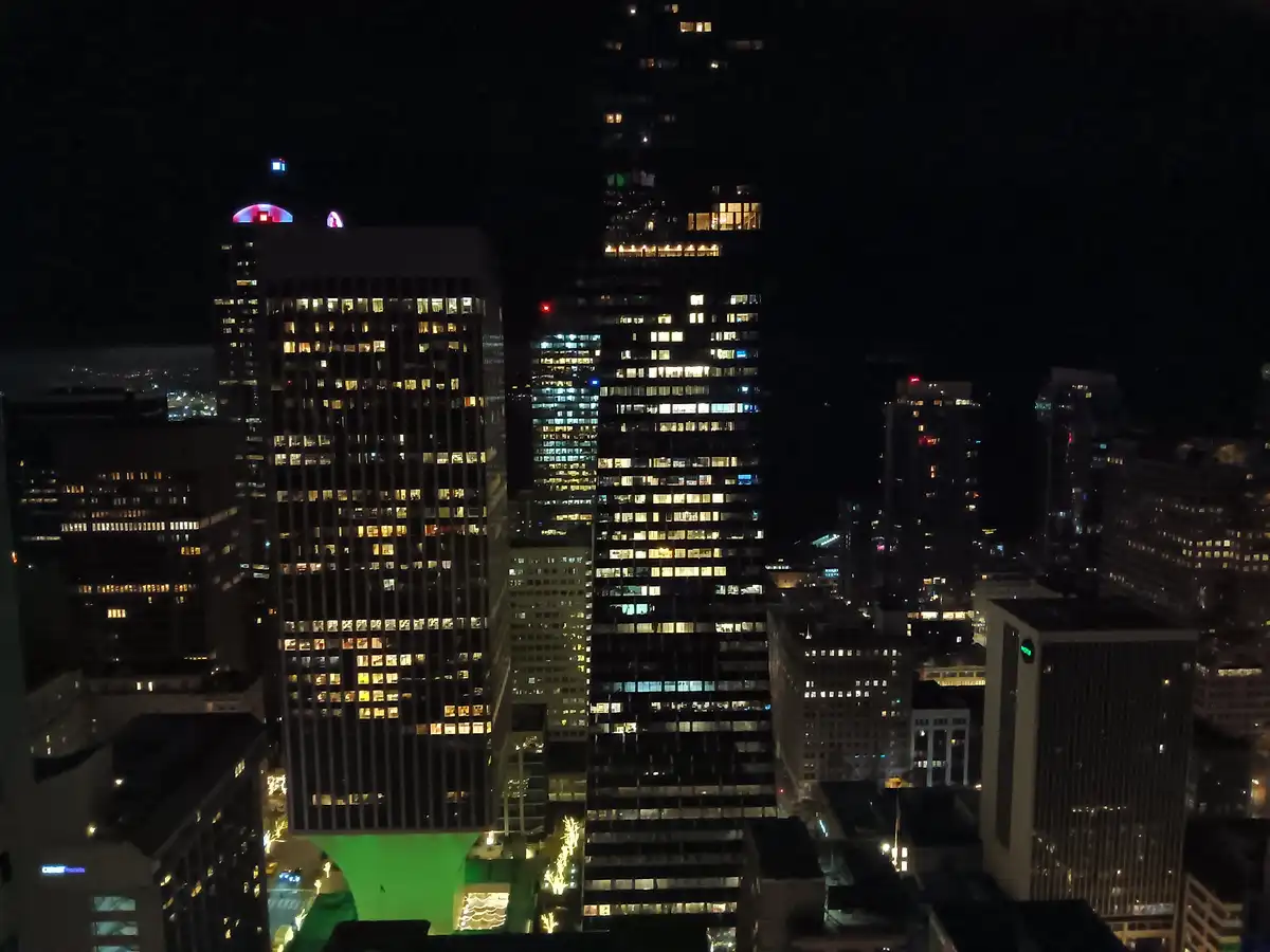 A nighttime cityscape of illuminated skyscrapers with scattered lit windows against a dark sky. The overlaid text reads 'i'm…