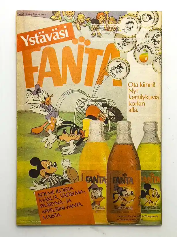 A vintage Finnish Fanta advertisement featuring Mickey Mouse, Donald Duck, and Goofy playing soccer on a field. Three Fanta…