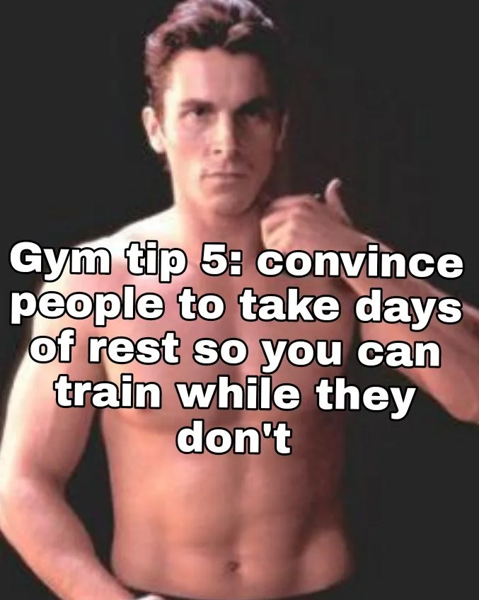 A shirtless, muscular man with dark hair stares intensely at the camera, his right hand raised in a thumbs-up gesture…