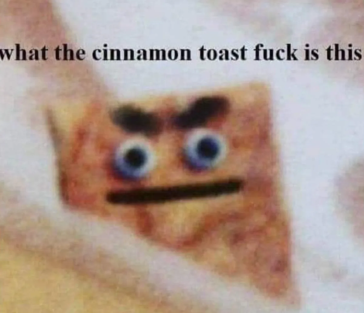 A blurry image of a square, brown, textured object resembling a piece of cinnamon toast with cartoonish blue eyes, dark…