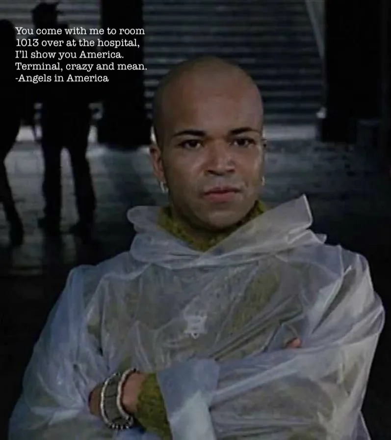 A bald man with a serious expression, wearing a clear plastic poncho over a green sweater and multiple bracelets, stands…