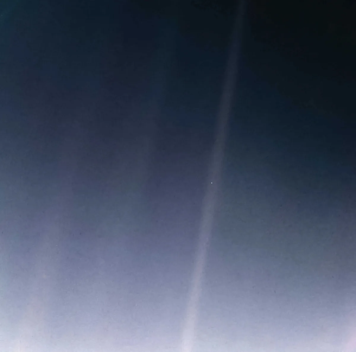 A blurry, dark blue sky image with a faint vertical light streak and a tiny dot resembling a star. Overlaid text reads 'i…