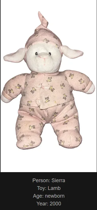A slightly worn, pink plush lamb toy dressed in a matching pink onesie with yellow patterns, standing upright against a…