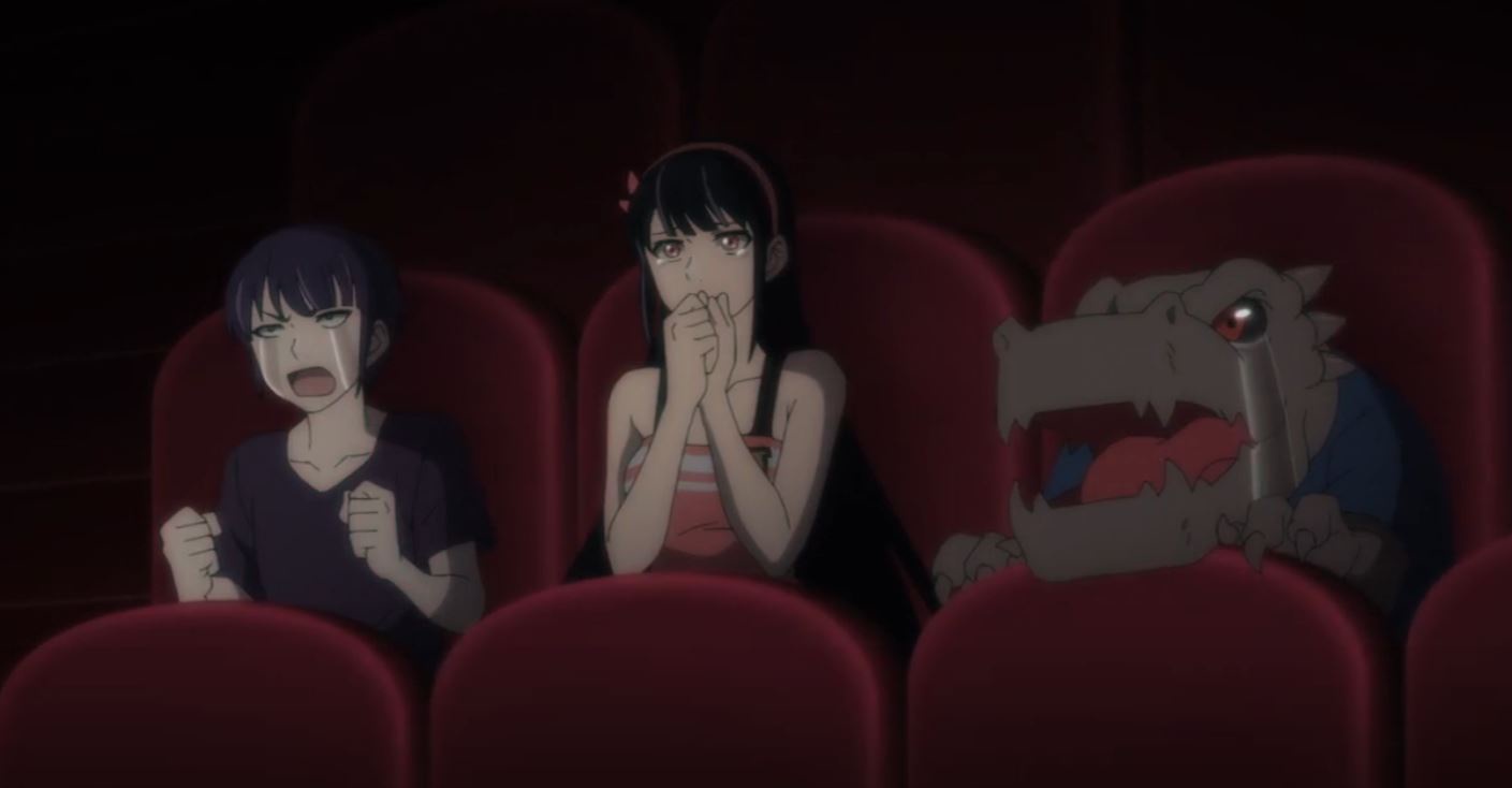 Three anime characters sit in a dark theater with red seats. The girl on the left is screaming with clenched fists, the girl…