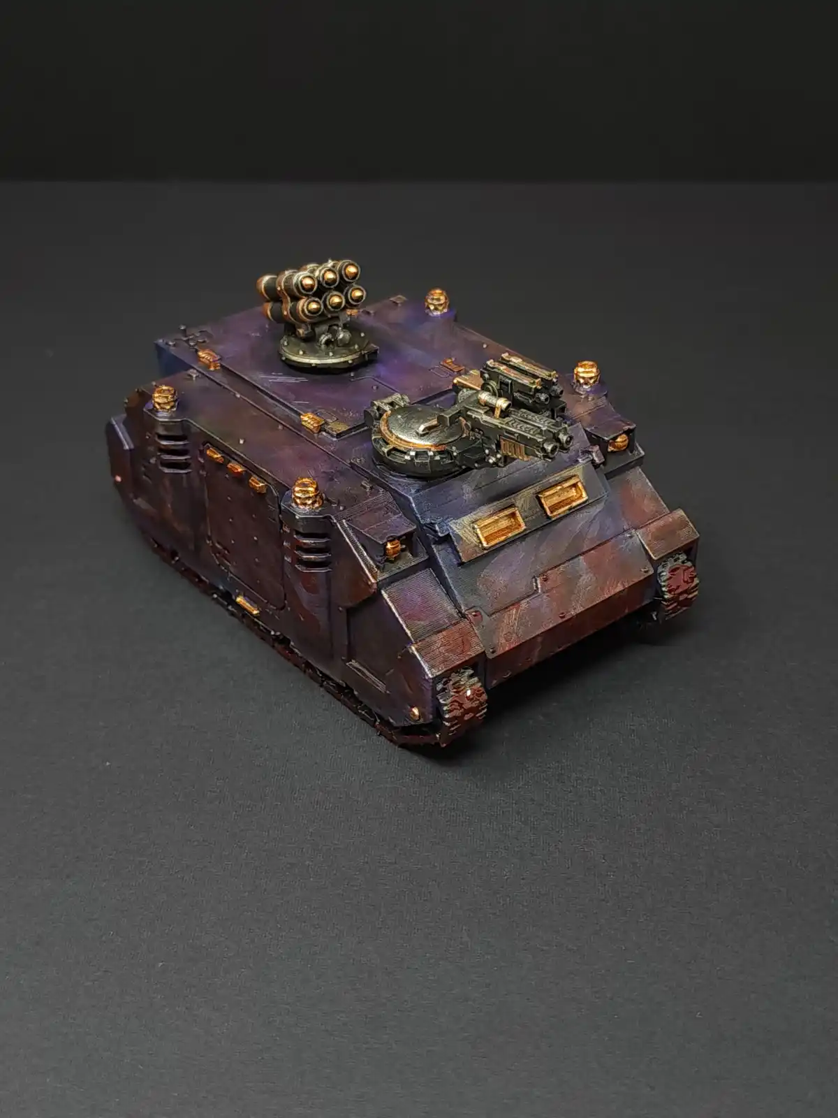 A highly detailed, hand-painted miniature of a futuristic armored vehicle, likely from Warhammer 40,000, featuring a purple…