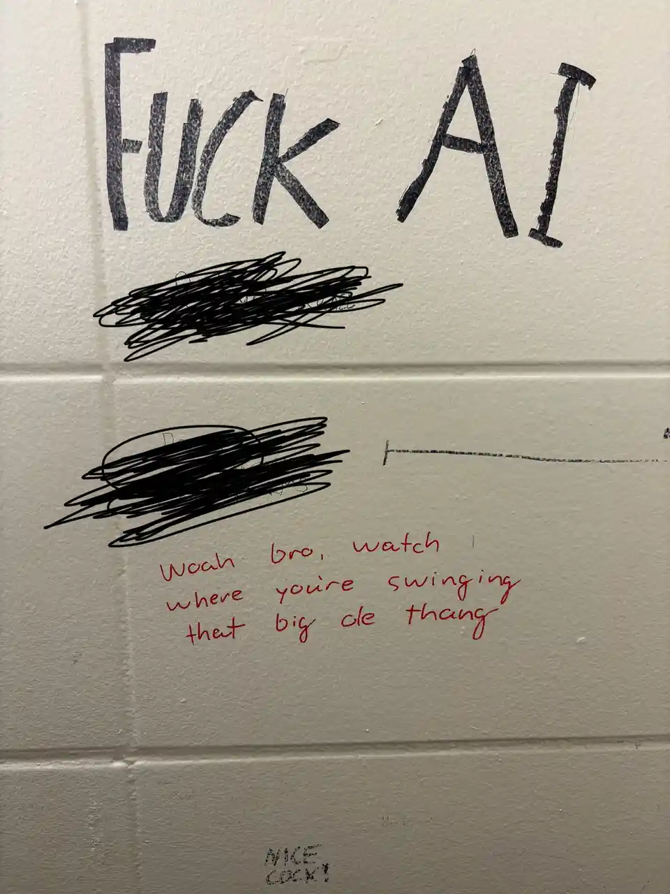 A close-up of a white cinder block wall with handwritten graffiti. At the top, large black letters spell 'Fuck AI'. Below…