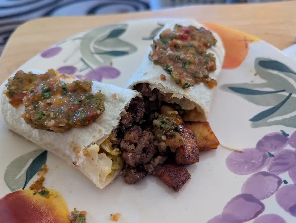 A burrito cut in half on a floral plate, revealing its filling of meat, potatoes, and salsa. The text overlay reads 'i'm not…