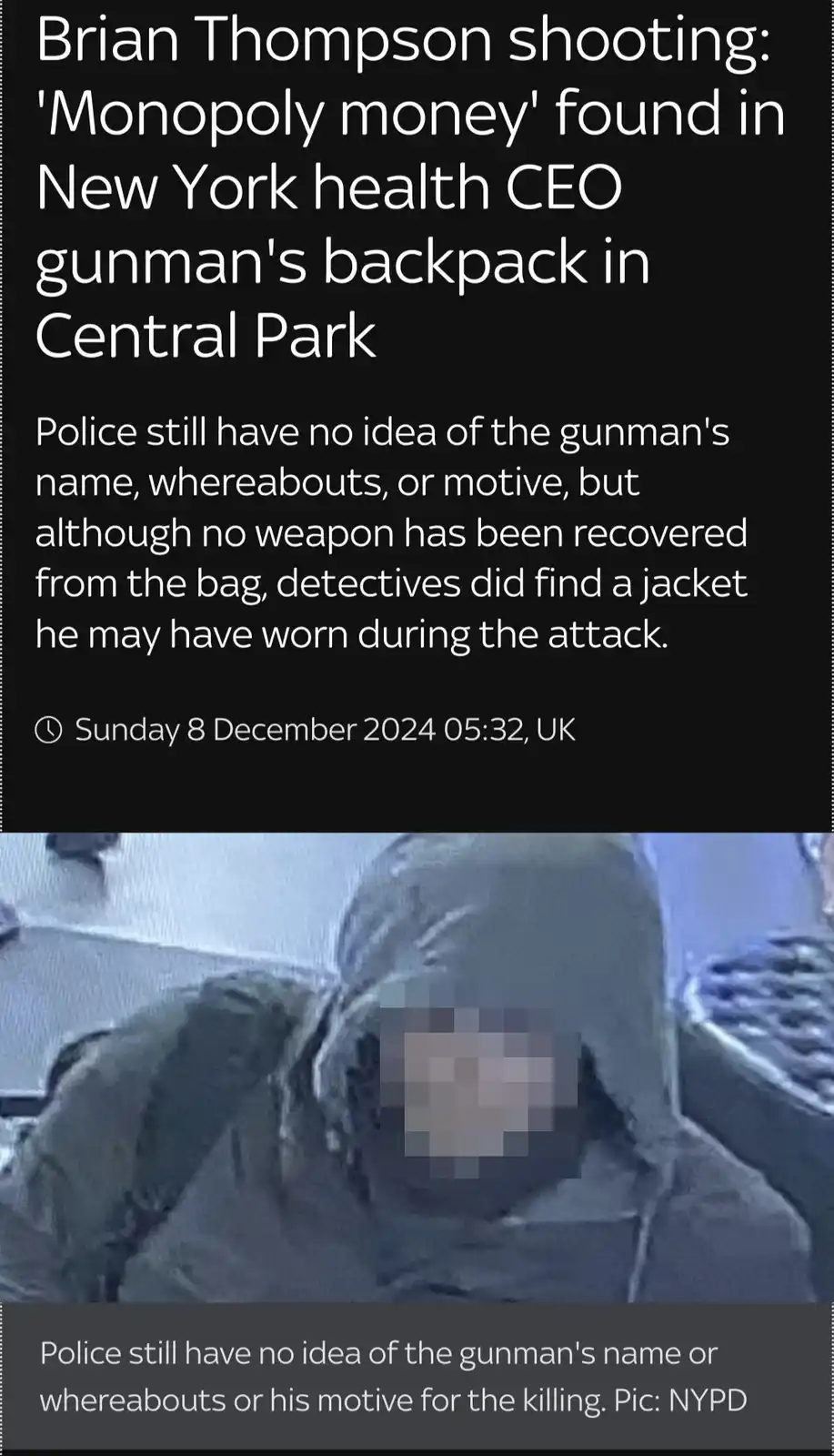 The image displays a low-resolution, grainy surveillance photo of a person wearing a dark hooded jacket with their face…