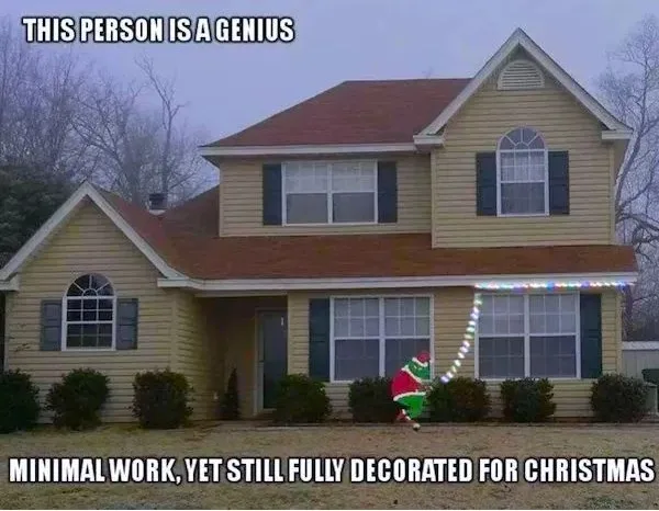 A two-story yellow house with dark shutters and a brown roof is shown with a single strand of colorful Christmas lights…