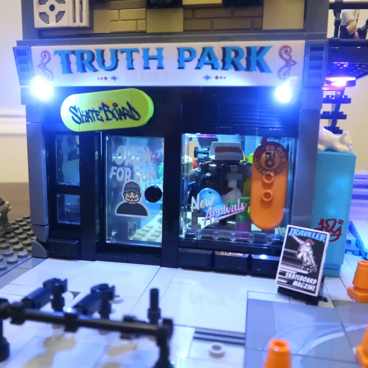 A Lego-built skate shop named 'TRUTH PARK SKATE SHOP' with a glowing sign, glass doors showing 'OPEN FOR FUN' and 'New…