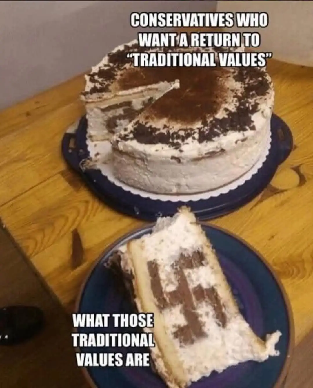 A partially eaten layered cake with chocolate and cream sits on a wooden table. A slice is on a plate in front, revealing a…