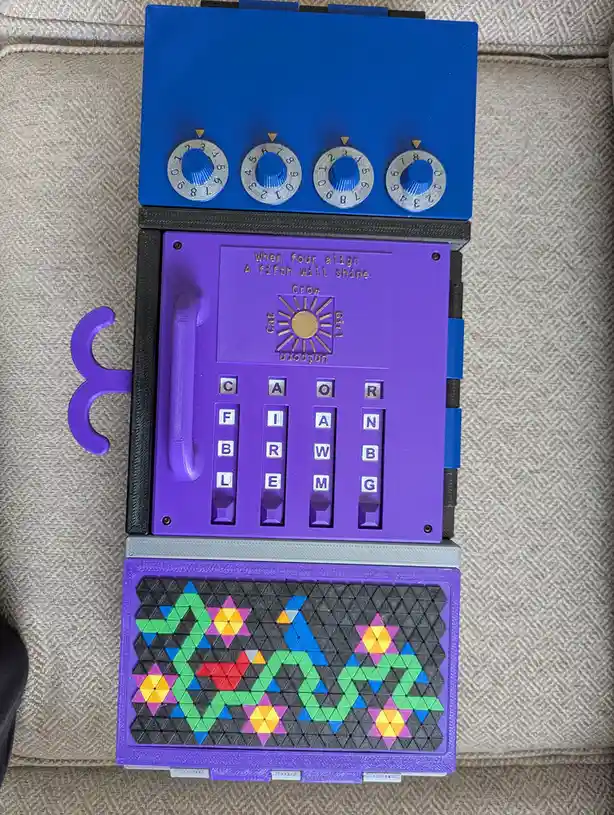 A custom 3D-printed puzzle device with a blue top panel featuring four numbered dials, a purple middle section with letter…