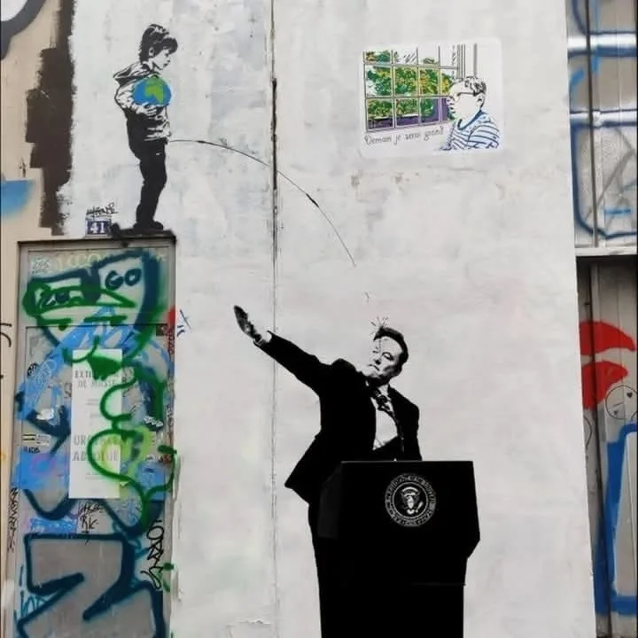 A street mural depicts a black-and-white image of a man in a suit at a podium with the presidential seal, gesturing upward…