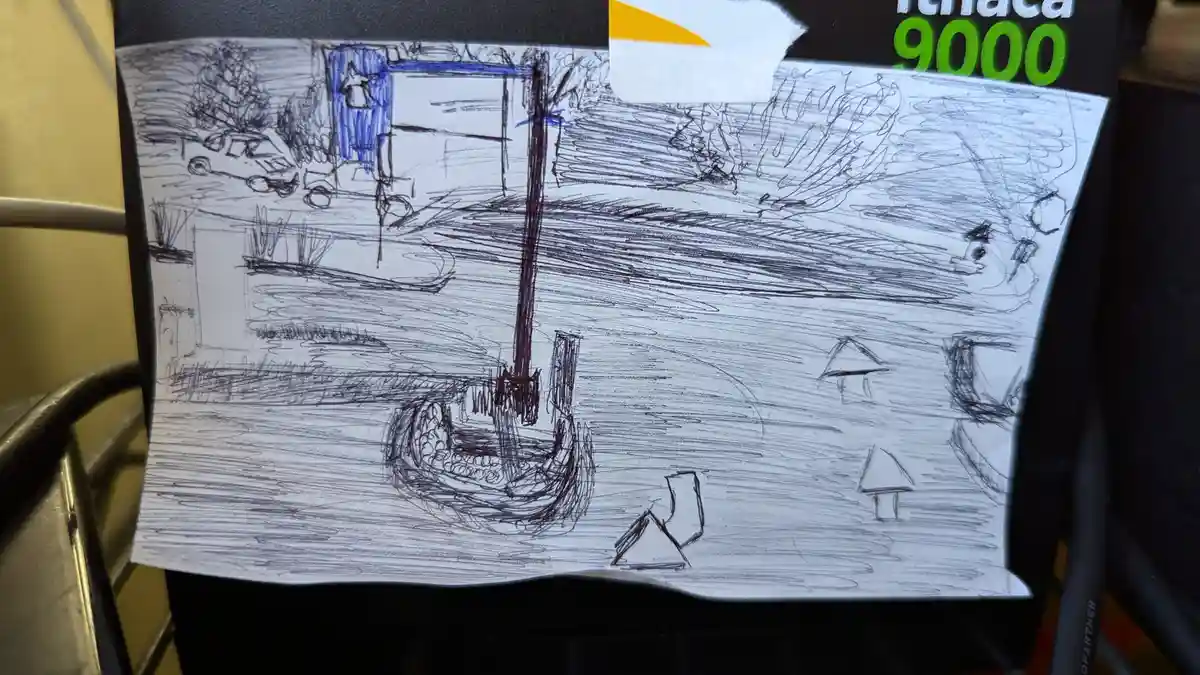 A child's sketch on paper taped to a black surface shows a boat with a tall mast in water, with simple houses and trees…