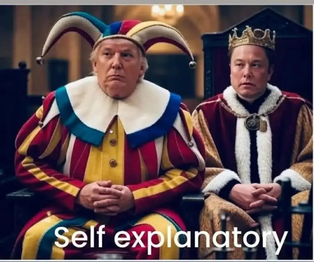 Two men sit side by side in royal attire; the man on the left wears a colorful jester costume with a multi-colored hat and a…