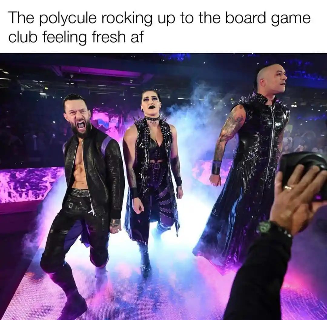 Three WWE wrestlers in dramatic, dark-themed costumes walk confidently down a lit stage with smoke effects, one screaming…