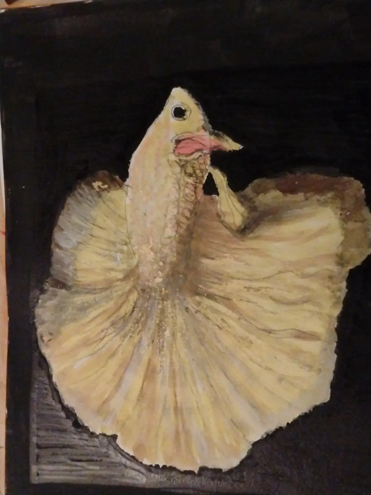 A watercolor painting of a fish with large, fan-like fins resembling bird wings, set against a dark background. The fish is…