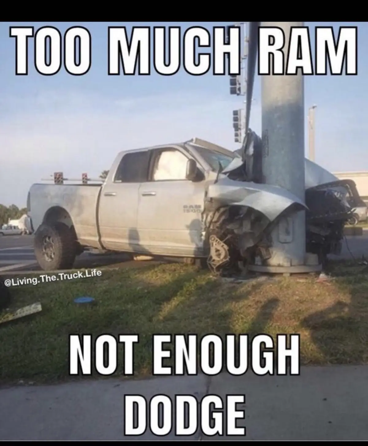 A silver Dodge Ram pickup truck is severely damaged after crashing into a metal utility pole at an intersection. The front…