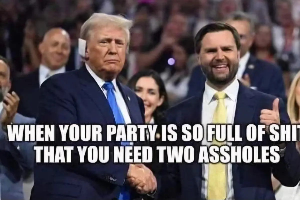 The image shows Donald Trump and Ron DeSantis standing side by side at a political event, shaking hands. Trump has a stern…