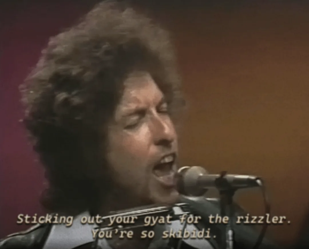 A grainy, vintage video still shows a man with curly hair singing passionately into a microphone. The overlaid text reads…