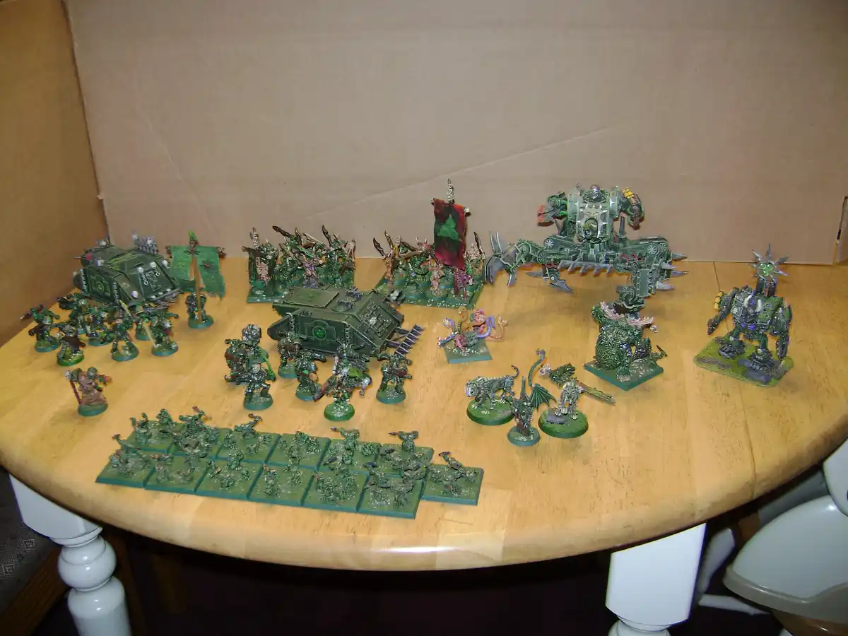 A large collection of green-painted Warhammer 40,000 miniatures, including infantry, vehicles, and monstrous creatures, are…