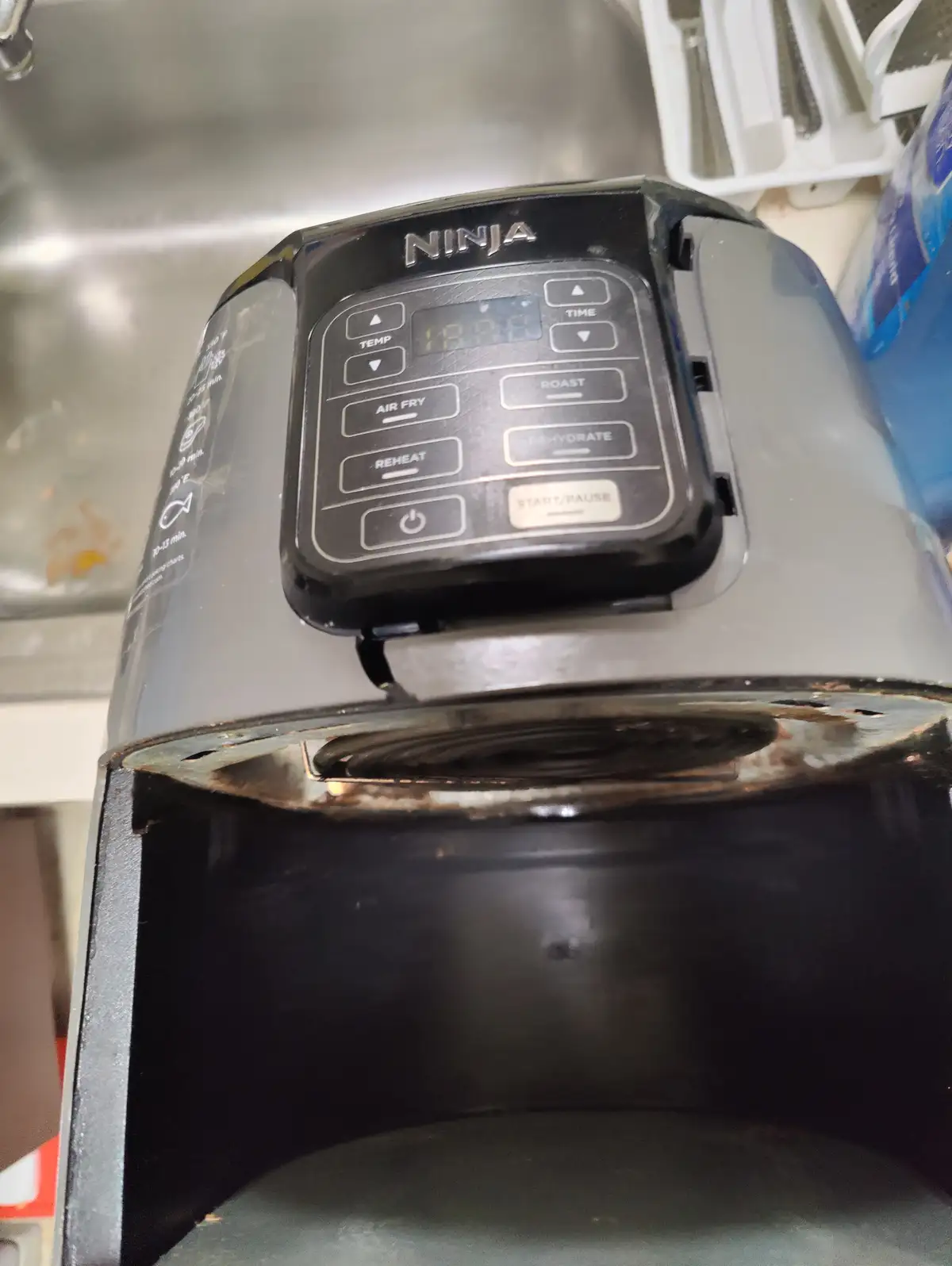 A close-up photo shows a black Ninja air fryer with its control panel visible, featuring buttons for Air Fry, Roast…