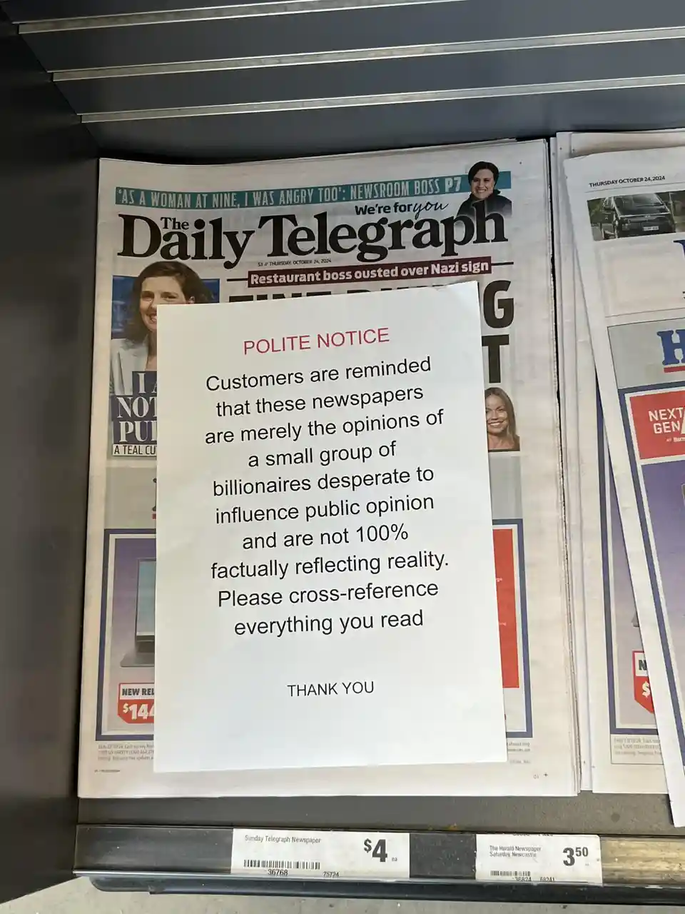 A 'polite notice' is taped over the front page of The Daily Telegraph newspaper, which features headlines about a restaurant…