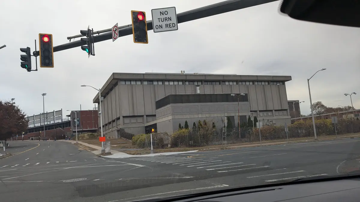 A photo taken from inside a car shows a traffic light with red signals illuminated, accompanied by a 'NO TURN ON RED' sign…