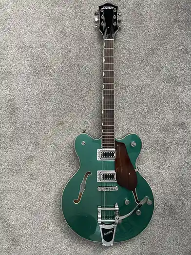 A green Gretsch electric guitar with a Bigsby tailpiece lies flat on a gray carpet. The overlaid text reads 'i got a new…