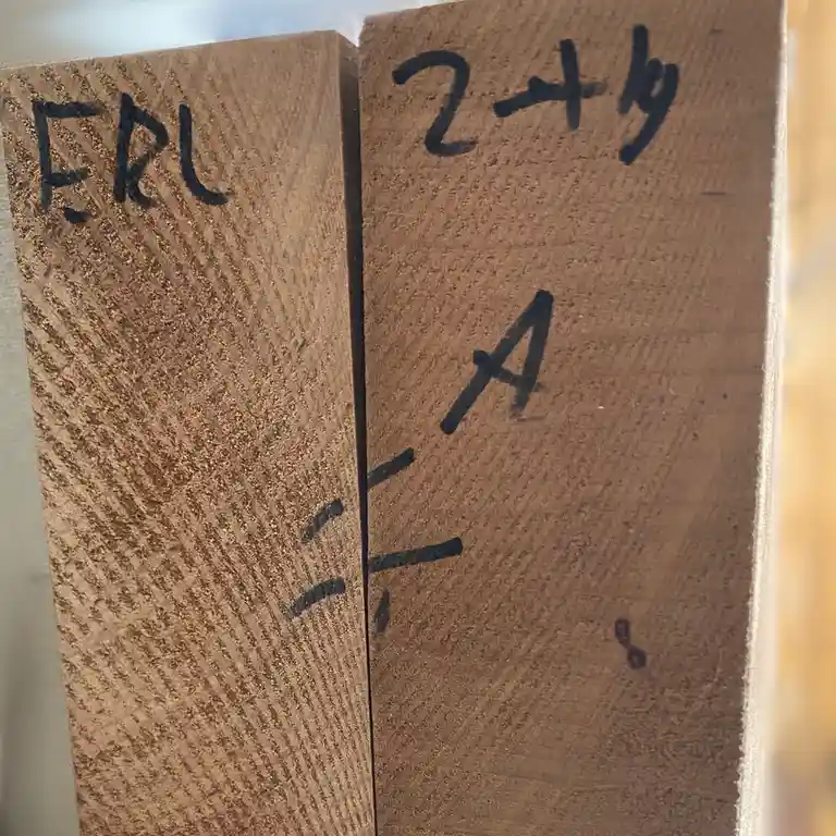 Two wooden blocks with black marker writing show 'ERL' on the left block and '2+4' above an 'A' on the right block, with…