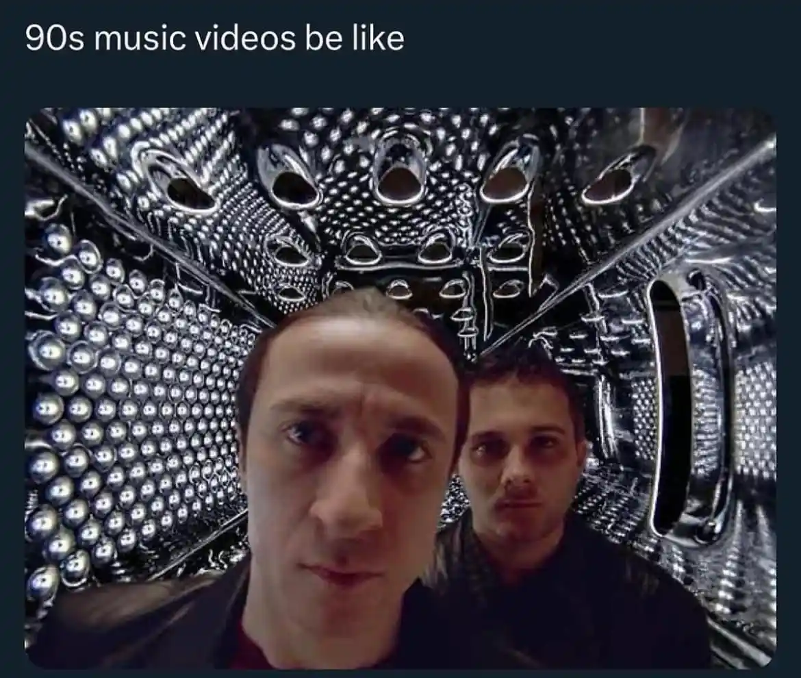 Two men stare intensely at the camera inside a highly stylized, metallic, and reflective tunnel with intricate patterns and…