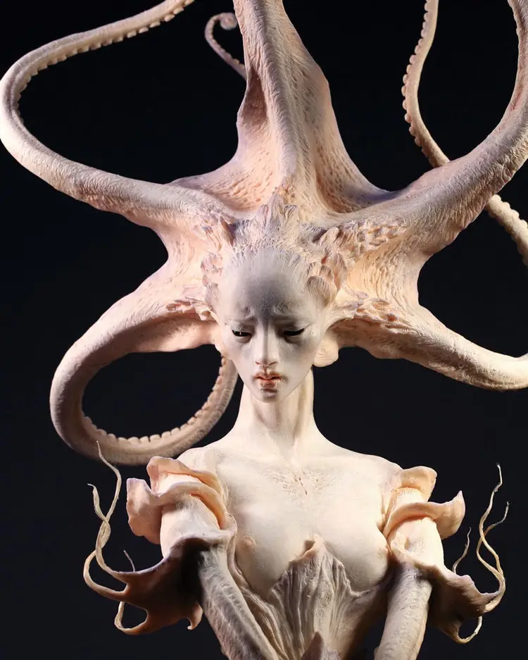 A highly detailed sculpture depicts a humanoid figure with a pale, serene human face and neck, but instead of a head, it has…