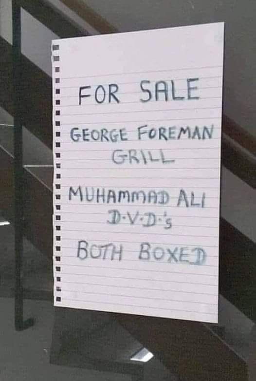 A handwritten note on lined paper taped to a glass surface reads 'FOR SALE GEORGE FOREMAN GRILL MUHAMMAD ALI D.V.D.'s BOTH…