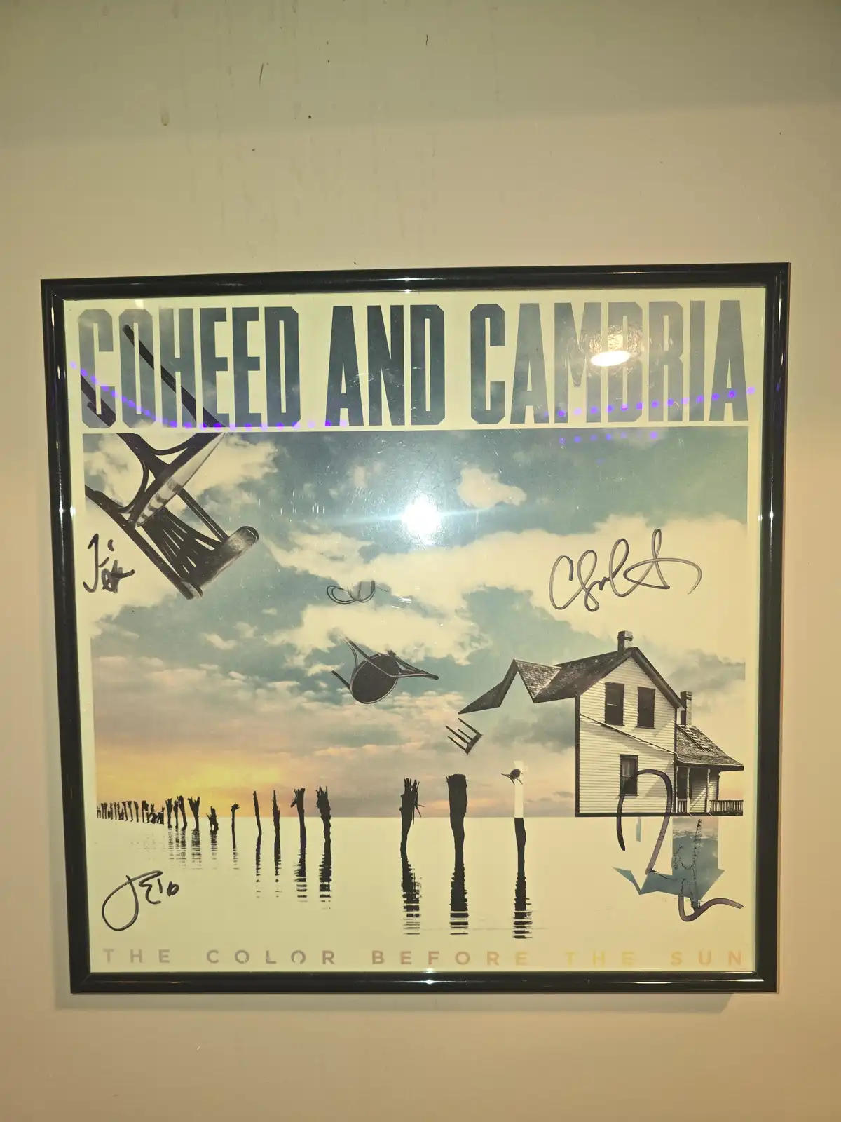A framed, signed poster for the band Coheed and Cambria's album 'The Color Before the Sun' shows a surreal scene with a…