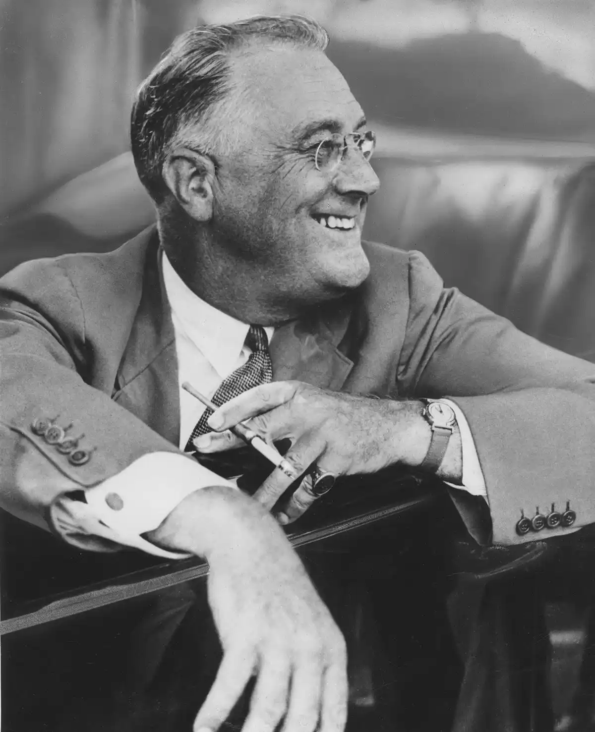 a black and white photo of a smiling man in a suit and glasses, holding a cigarette, with overlaid text that reads 'i'm not…