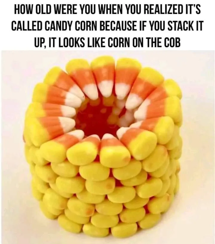 An image shows candy corn candies stacked vertically to form a cylindrical shape resembling an ear of corn on the cob, with…