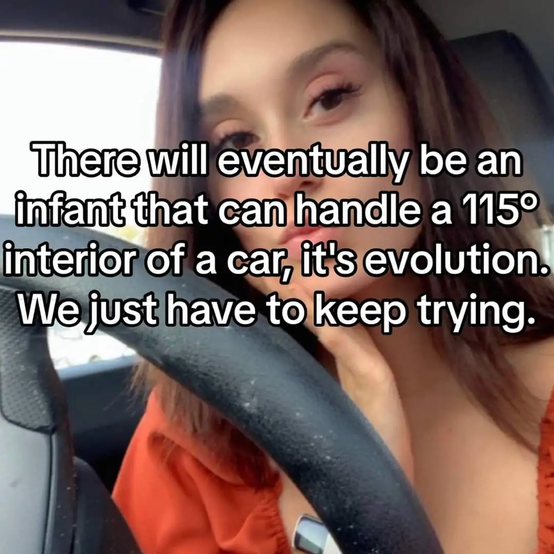A woman sits in the driver's seat of a car, looking directly at the camera with a weary expression, her hand resting near…