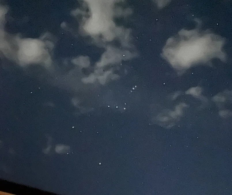A night sky photo showing scattered stars and wispy clouds, with overlaid text reading 'i saw a star fall and i didn't even…