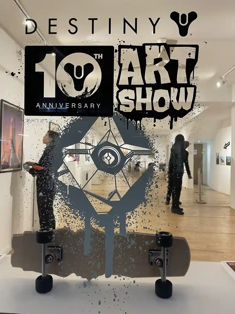 A photo of an art gallery interior with people viewing artwork, overlaid with a large graphic that reads 'DESTINY 10TH…
