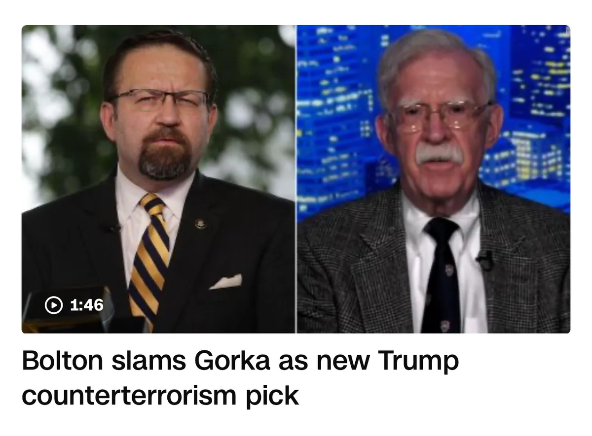 The image shows two men side by side: on the left, a man with glasses and a beard wearing a suit and yellow-striped tie, and…