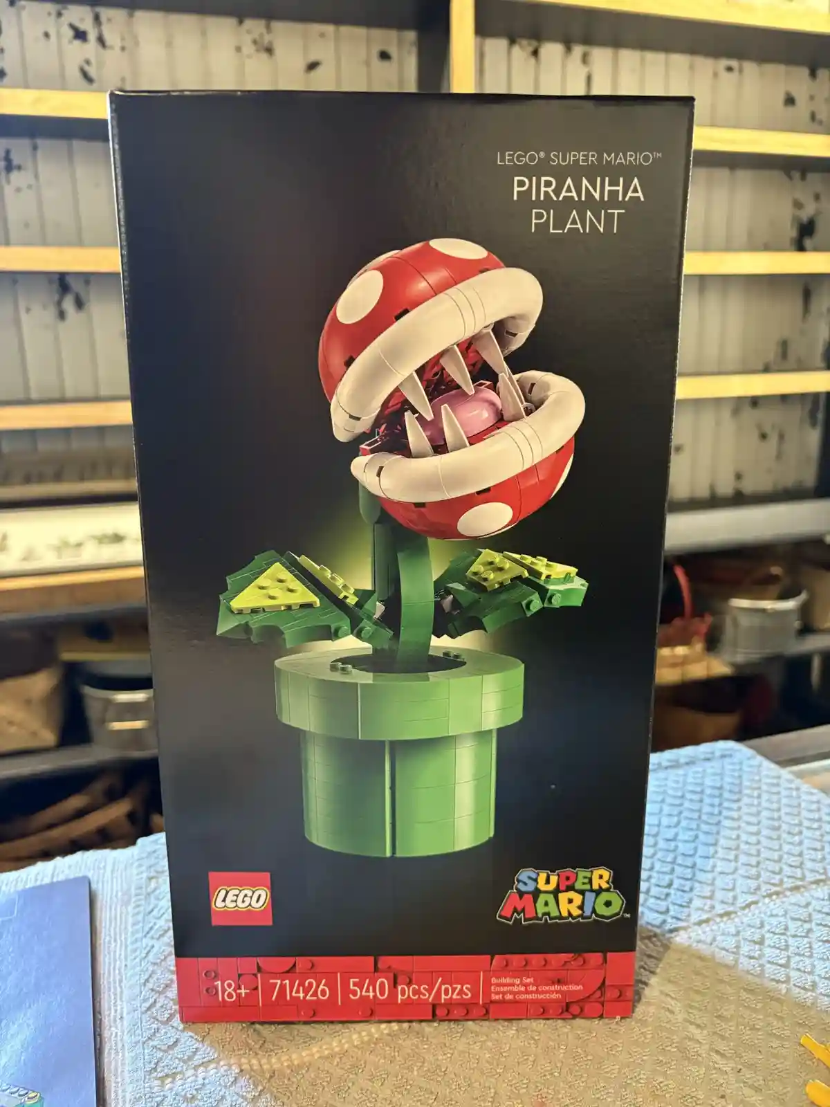 A black LEGO Super Mario Piranha Plant building set box (set #71426) is shown, featuring an image of the red and white…