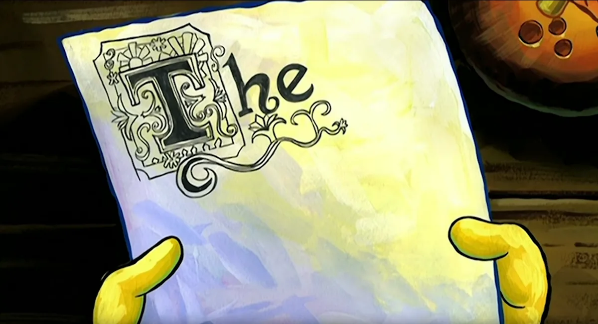 A close-up shot shows two yellow cartoon hands holding up a piece of parchment paper. The paper has an ornate, decorative…