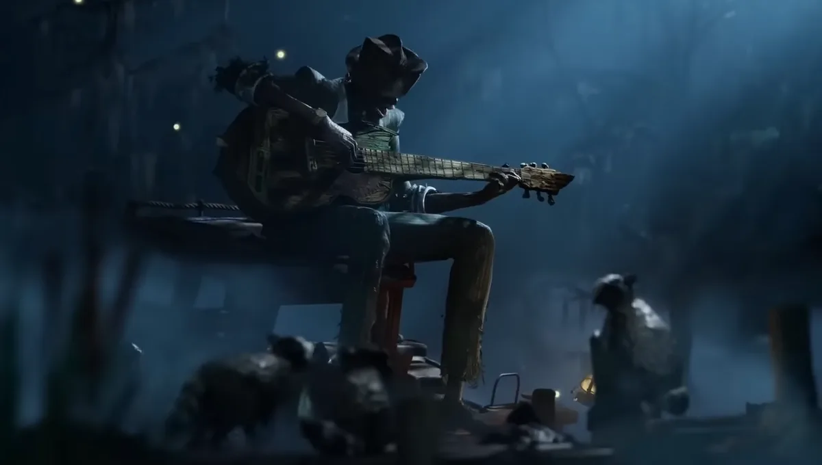 A dark, atmospheric image shows a ragged, scarecrow-like figure in a cowboy hat playing an acoustic guitar while seated on a…