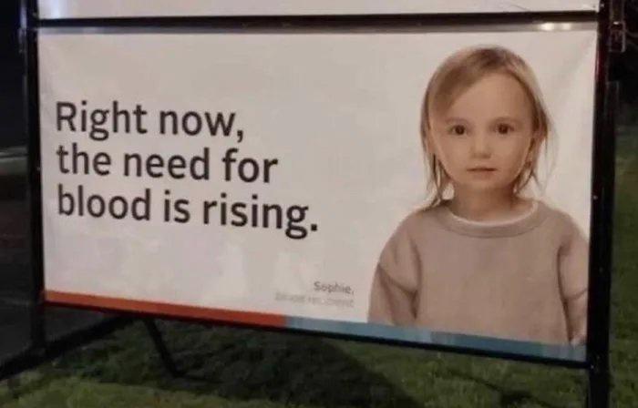 A public service announcement billboard features a young girl with a solemn expression, wearing a beige sweater. The text on…