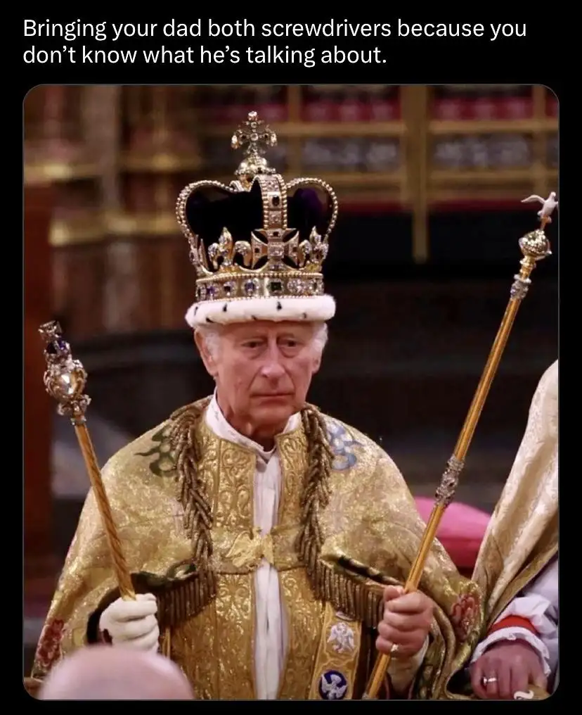 A man wearing a jeweled crown and ornate golden robe holds two ceremonial scepters, looking confused or exasperated. The…