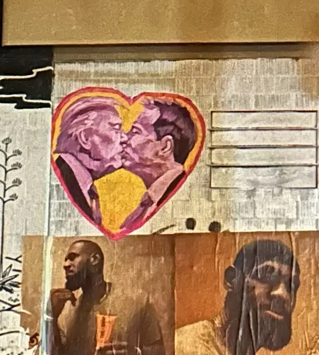 A collage-style artwork features a heart-shaped illustration of two men kissing, positioned above two separate portraits of…