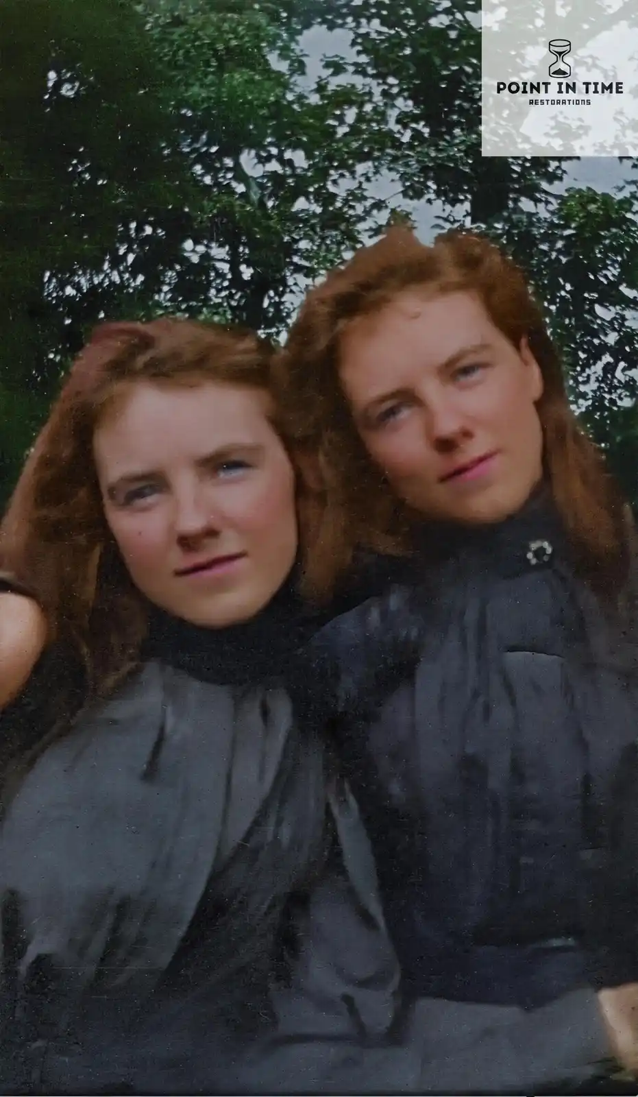 A vintage, slightly faded color photograph shows two young women with reddish-brown hair posing closely together outdoors…