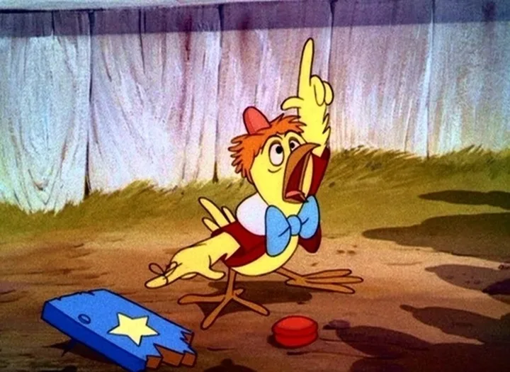 a cartoon yellow chicken wearing a red vest, blue bowtie, and red hat stands on dirt ground with a shocked expression…